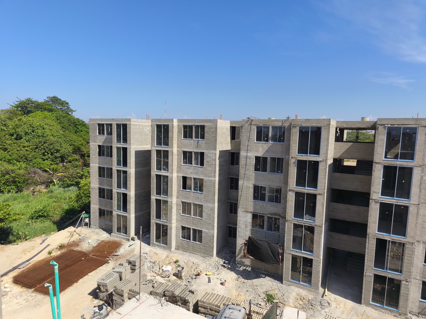 Torres de 5 pisos en obra gris con bloque a la vista en Puerto Verde